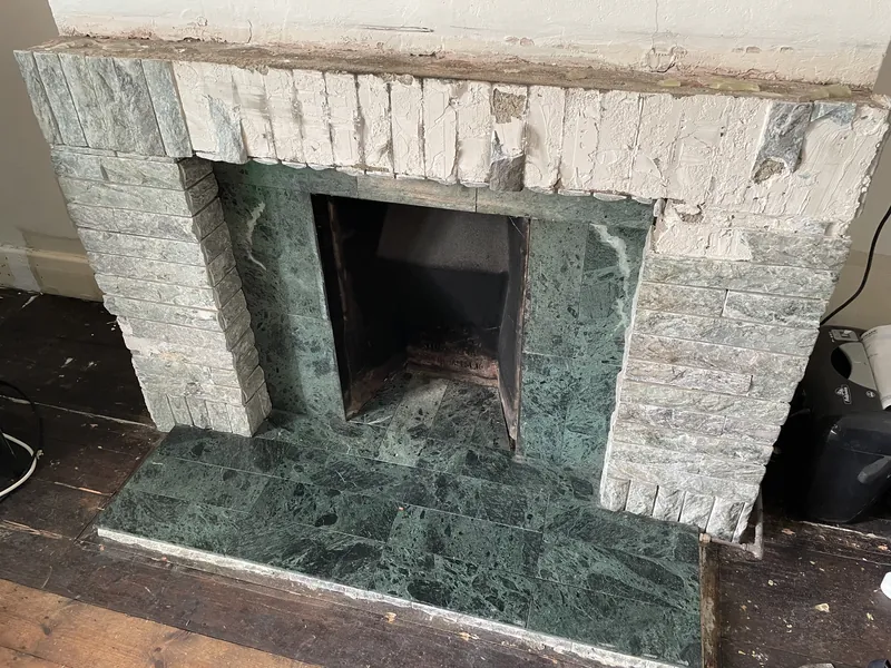 Fireplace opening restoration: Before: marble-faced surround and hearth